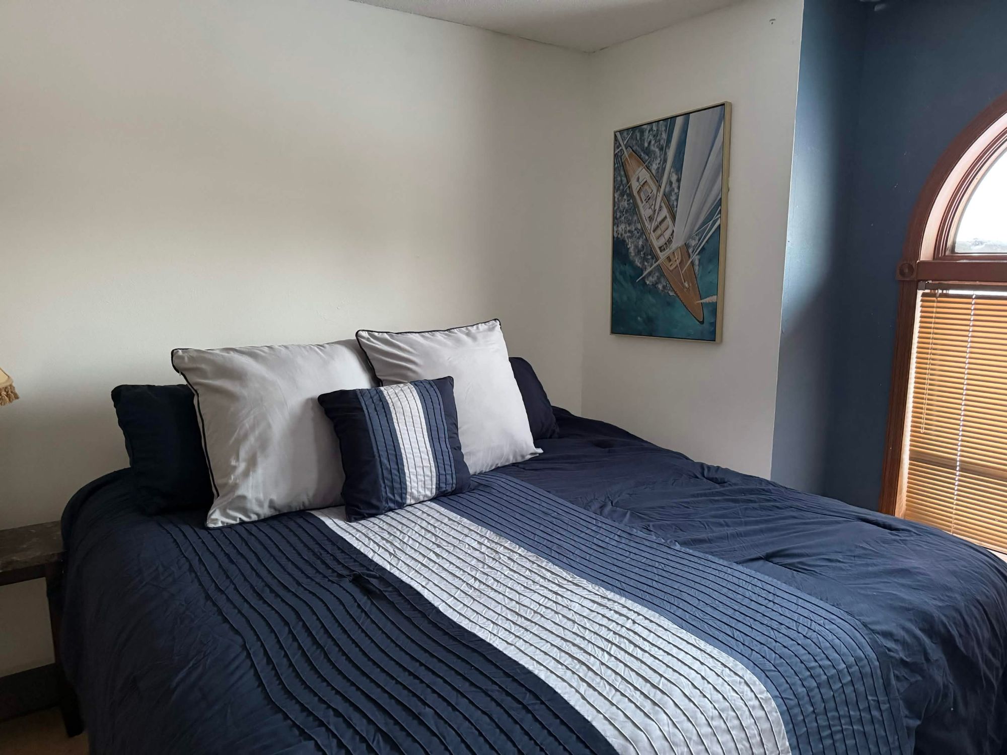Bedroom with navy bedding and sailboat painting