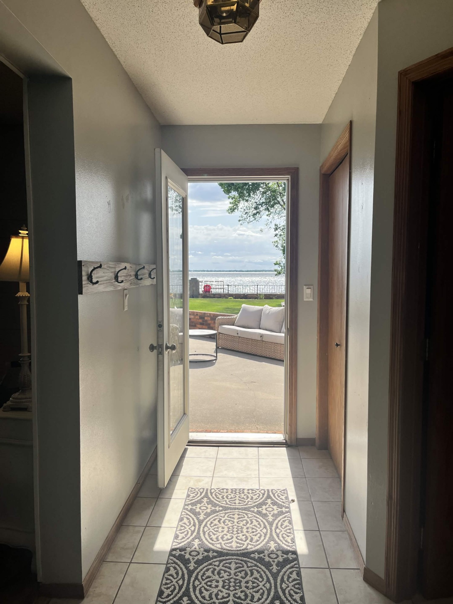 Tiled back entry with the door open to the patio and lake